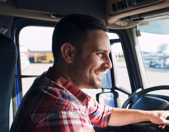 Truck driver at the wheel of his rig enjoying Chevron Denali Express' Fleet Program