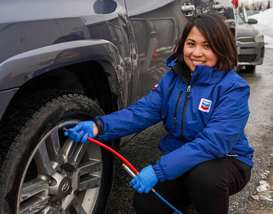 Denali Express Chevron Network employee helps put air in tires.
